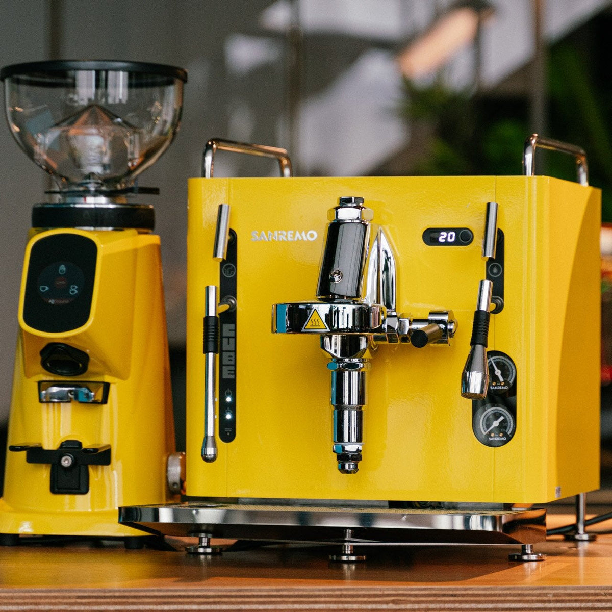 Yellow coffee machine on a wooden surface with a blurred background