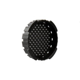Black circular object with textured surface on a white background
