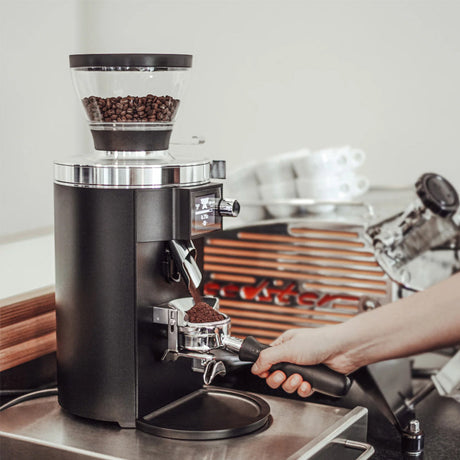 Coffee grinder with coffee beans on a kitchen counter