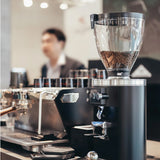 Coffee grinder with coffee beans in a coffee shop setting