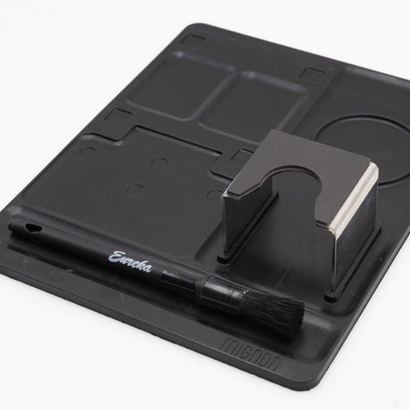 Black knife sharpener with a brush on a white background