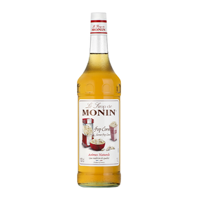 A bottle of Monin Popcorn flavor syrup with the label showing an illustration of a popcorn machine and text indicating the product name and size.