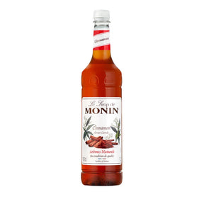 A bottle of Monin Coffee Syrup with cinnamon roll flavor, 1 liter size.