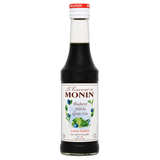 Bottle of Monin Blueberry Matcha Green Tea syrup on a white background