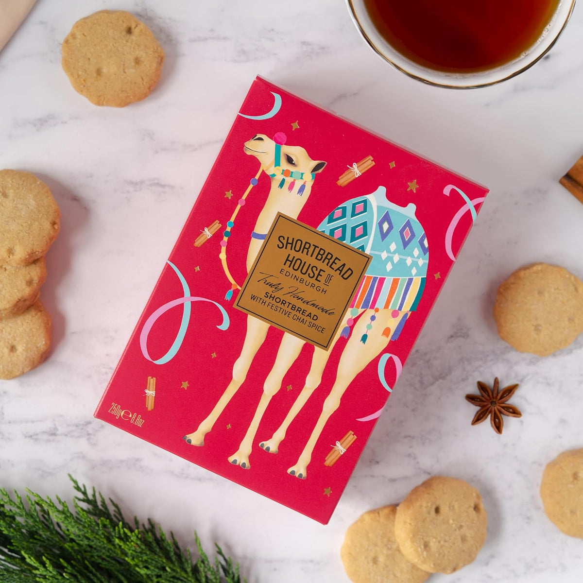 Red box with camel design and cookies on a marble surface