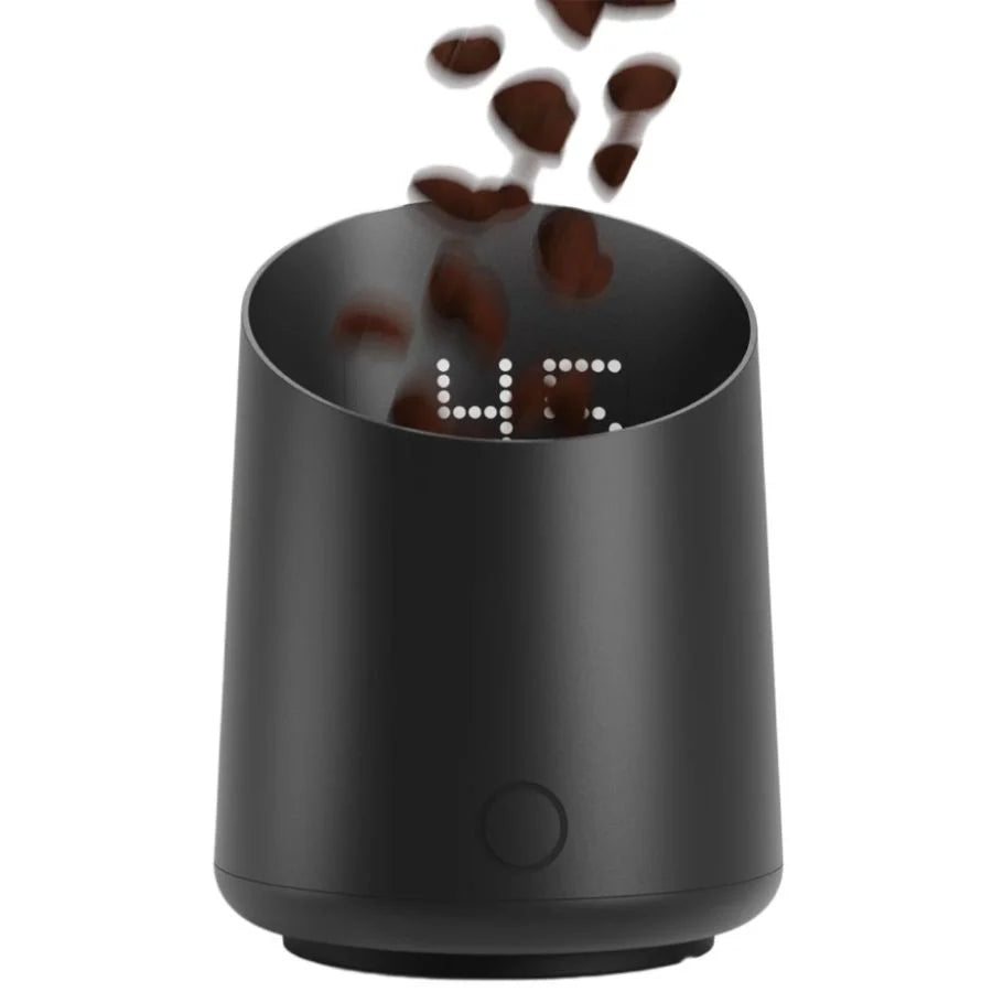 Black digital clock with coffee beans falling into it on a white background