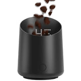 Black digital clock with coffee beans falling into it on a white background