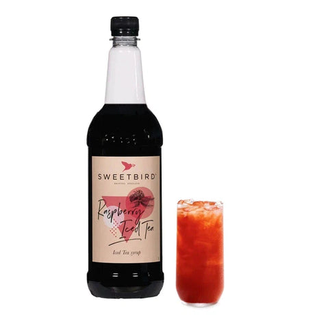 A bottle of Sweetbird Raspberry Iced Tea Syrup with a glass of iced tea with raspberry syrup on the side.