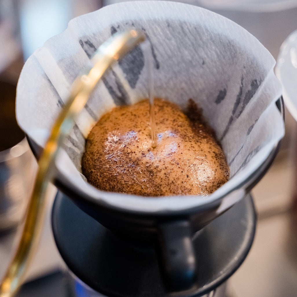 Coffee being poured into a coffee filter with a blurred background